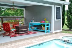 a pool side patio with chairs and a table