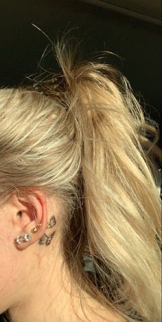 a woman with blonde hair and piercings on her ear