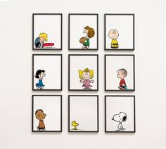 a group of cartoon characters hanging on the wall in front of a white wall with black frames