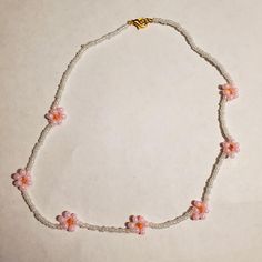 Having a flower Easter vibe with this cute choker. I used 2 Glass Seed beads colors and 1 E-bead color to make this. I put a lobster clasp and a ring hoop at the end of the bracelet to secure it. The string that I use is elastic and it has a little bit of a stretch.  I added a few scoops of each color to my wooden bead spinner. So each bracelet and necklace I make is unique in design. Pink Beaded Dainty Choker, Trendy Beaded Flower Necklace Gift, Pink Flower Necklaces With Tiny Beads, Pink Flower-shaped Necklace With Tiny Beads, Pink Flower Necklace With Tiny Beads, Trendy Handmade Flower Beaded Necklaces, Handmade Flower Choker For Summer, Handmade Flower Shaped Choker For Summer, Handmade Cute Flower Beaded Necklaces