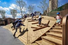 several children are playing on a wooden ramp