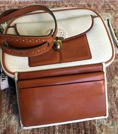 This elegant shoulder bag is very versatile: for business, travel, and daily use- it fits all the purposes. It has an integrated brown documents/money holder, and has multiple compartments and pockets: Exterior- one open, one buckled, one zipped compartment. Interior- 2 compartments for cards, 3 pockets, and 3 compartments in the integrated wallet. Measurements: Height of the bag- 7" Width- 9" Depth- 3" The width of the integrated docs/money folder- is 6 ½" Adjustable strap- 15"-18" The bag is n Cognac Travel Bag With Interior Card Slots, Classic Shoulder Bag With Interior Card Slots For Travel, Brown Travel Wallets With Detachable Strap, Formal Brown Shoulder Bag With Cell Phone Pocket, Brown Shoulder Bag With Detachable Strap For Business Trips, Travel Wallet With Detachable Strap, Classic Travel Shoulder Bag With Cell Phone Pocket, Classic Shoulder Bag With Cell Phone Pocket For Travel, Vintage Wallet With Removable Pouch For Travel