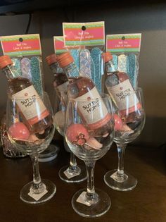 three wine glasses filled with pink and white balls in front of each other on a table