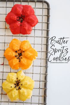 three different colored cookies on a cooling rack