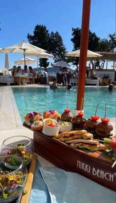 an outdoor pool with food and drinks on it