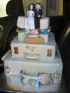 a wedding cake made to look like suitcases with bride and groom figurines on top