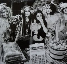 three women dressed in costumes standing next to each other near a calculator and sign