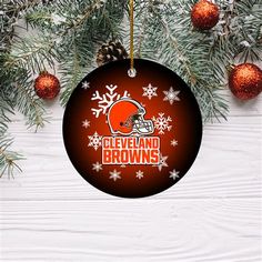 cleveland browns christmas ornament hanging on a tree with snowflakes and pine cones