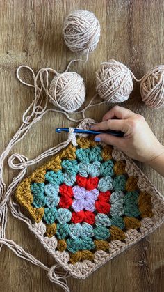 someone is crocheting together on the floor with balls of yarn