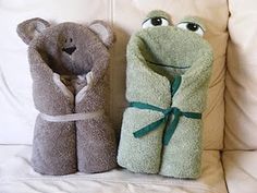 two towels folded in the shape of a frog and a teddy bear sitting on a couch