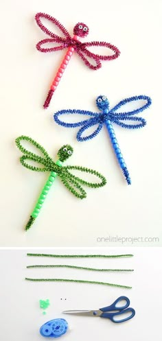 three dragonflys made out of beaded string and scissors on a white surface