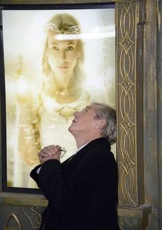 a man standing in front of a large poster