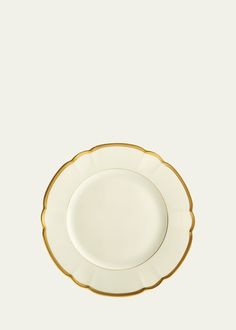 an empty white plate with gold trim