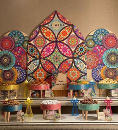 an elaborately decorated buffet with colorful plates and desserts on it's sides