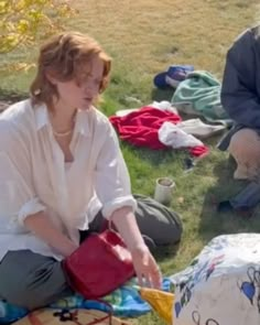 two women sitting on the ground with bags