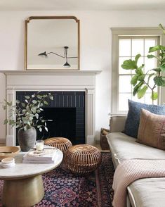 a living room filled with furniture and a fire place in front of a mirror on the wall