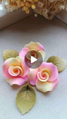 three pink and yellow roses sitting on top of a table