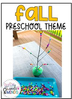 a blue tray with beads on it next to a green vase filled with flowers and the words fall preschool theme