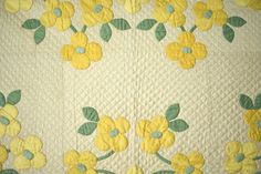 a yellow and green quilt with flowers on it