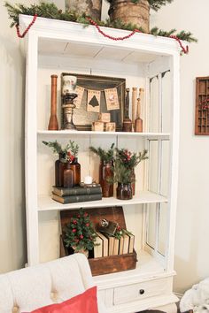 a white book shelf filled with books and christmas decorations