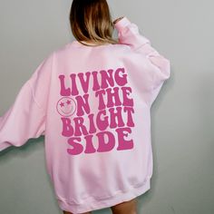 Living on the Bright Side Trendy Crewneck YOUR SIZE NOT AVAILABLE? Send us a message and we will see what we can do! ::INFO:: * 50% cotton 50% polyester * Graphic is high-quality screen printed to be durable and long-lasting! * Wash and dry normally (cool settings or air dry for best results) ::SIZING:: * Sizing is unisex so runs like mens, however not overly large * Most women find their normal size works, since they are meant to fit a bit loose. * SIZE UP FROM YOUR REGULAR SIZE IF YOU ARE GOIN College Graphic Print Drop Shoulder Sweatshirt, College Drop Shoulder Graphic Sweatshirt, Pink Relaxed Fit Hoodie For Leisure, Oversized Pink Sweats For Streetwear, Trendy Screen Print Sweatshirt For Loungewear, Relaxed Fit Slogan Hoodie For Loungewear, Pink Letter Print Sweats For Streetwear, Pink Letter Print Sweatpants For Streetwear, Oversized Hooded Top With Screen Print