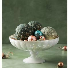 a white bowl filled with ornaments on top of a table