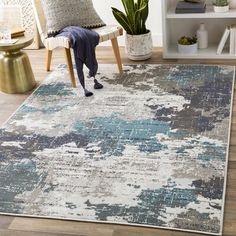 an area rug with blue and white paint splattered on it in a living room