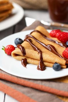 pancakes with chocolate sauce and strawberries on a plate