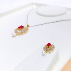 Vibrant Upscale Diamond Pendant Set. Crafted from 18k yellow gold, this stunning set features a total diamond weight of 1.37ct, with high-quality F-G color and VS clarity. The pendant showcases a brilliant round cut diamond paired with an elegant cultured ruby and pearl, while the earrings boast an emerald cut stone. With a pendant length of 1.5" and included screw back earrings, this set is the perfect addition to your high fashion collection. PRODUCT DETAILS Gold Purity(karat): 18k Gold Weight Exquisite White Gold Jewelry Sets With Brilliant Cut, Elegant White Jewelry Sets With Brilliant Cut, White Ruby Jewelry Sets For Gift, Elegant White Gold Diamond Necklace With Ruby, Classic White Diamond Jewelry Sets, Classic Diamond Jewelry Sets In White, White Diamond Jewelry Sets With Brilliant Cut, White Round Diamond Jewelry Sets, Brilliant Cut Diamond White Fine Jewelry Sets