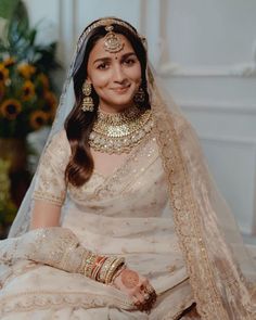 a woman sitting on the ground wearing a bridal outfit