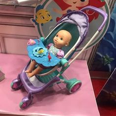 there is a doll sitting in a baby stroller on the table next to other toys