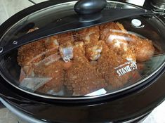 a crock pot filled with fried food sitting on top of a table