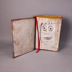 an open book with a face drawn on it