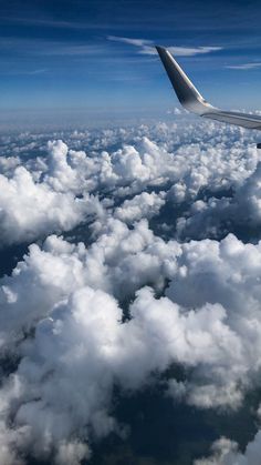 an airplane wing flying above the clouds