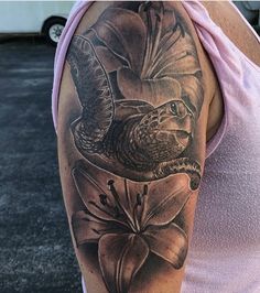 a woman with a bird and flower tattoo on her arm