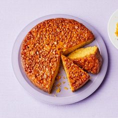 a cake on a plate next to a bowl of orange zesty crumbs