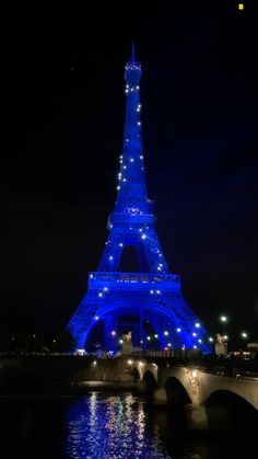 the eiffel tower lit up in blue at night