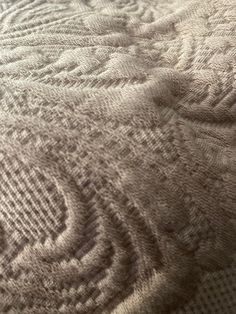 a close up view of a blanket on a bed