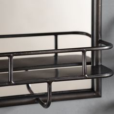 a metal shelf with two shelves on each side and a mirror behind it in front of a wall