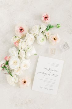 the wedding stationery is laid out with flowers