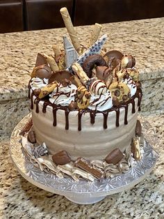 a cake with chocolate icing and cookies on it sitting on a counter top next to a knife