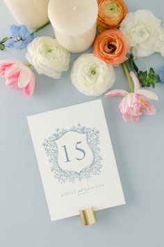 a table with flowers and candles on it next to a card that reads 15 th anniversary