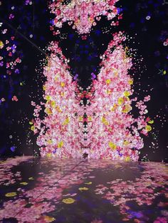 an artistic display with pink and yellow flowers floating in the air on a black background