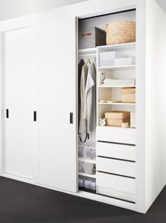 an open closet with white drawers and shelves