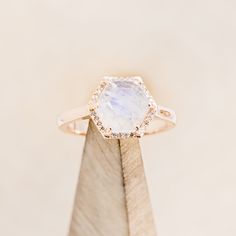 a close up of a ring on top of a piece of wood with a stone in the middle