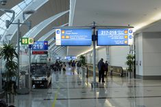 people are walking through an airport terminal with their luggage bags on the conveyor belt