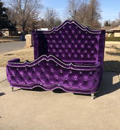 a purple bed sitting on top of a sidewalk