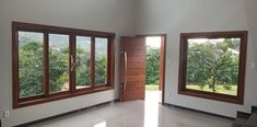 an empty living room with large windows and doors