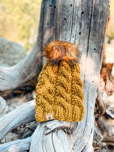 a knitted hat sitting on top of a tree stump