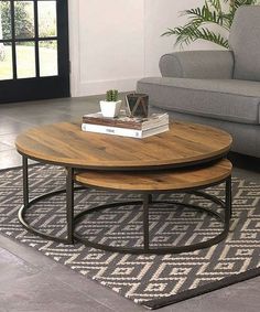 two tables sitting on top of a rug in front of a gray couch and chair